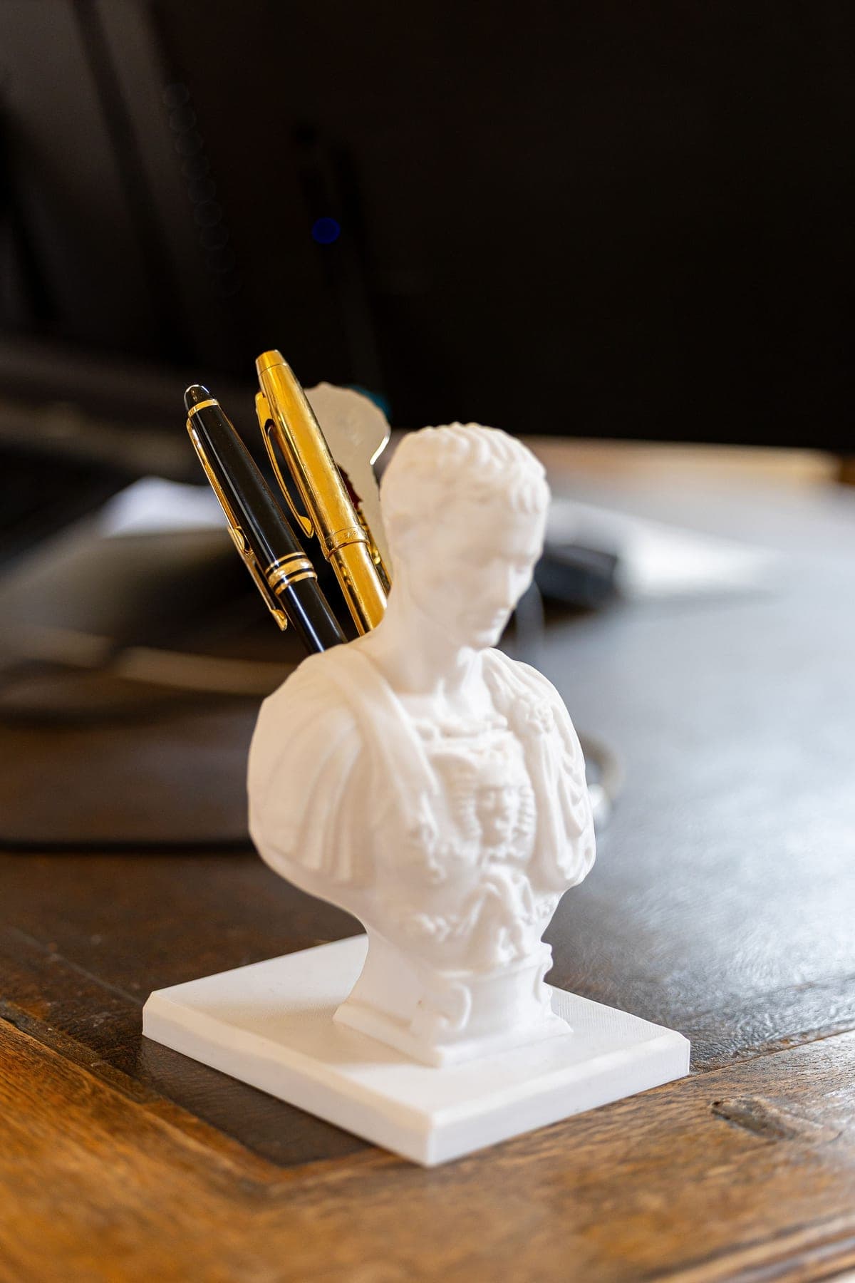 Twee vulpennen in een wit borstbeeld op het bureau van NOOR Advocatuur